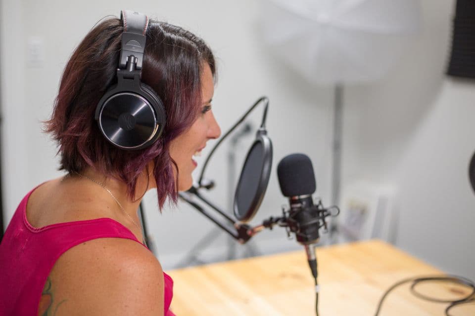 Woman recording speech at a studio microphone