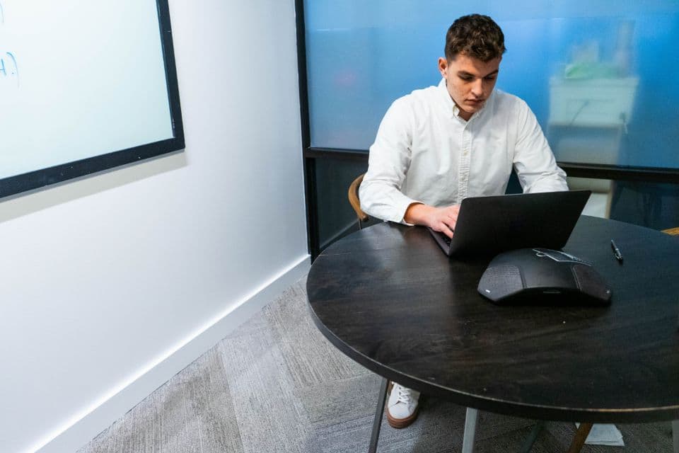 Man working on a laptop at a round table