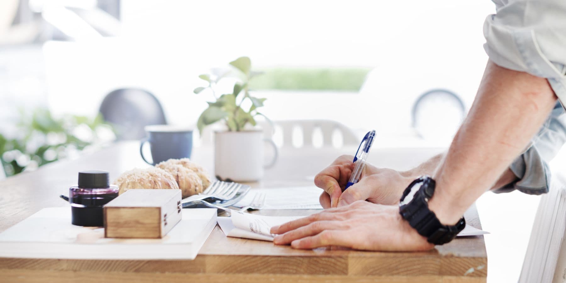 Person signing a document at a desk